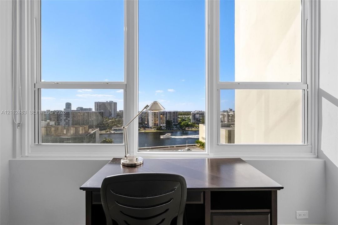 Large multi-pane window with white framing, providing natural light and exterior water and cityscape scenery