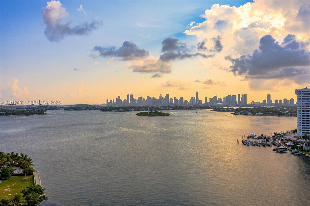 Expansive water frontage featuring a panoramic cityscape, marina docks, and coastal greenery