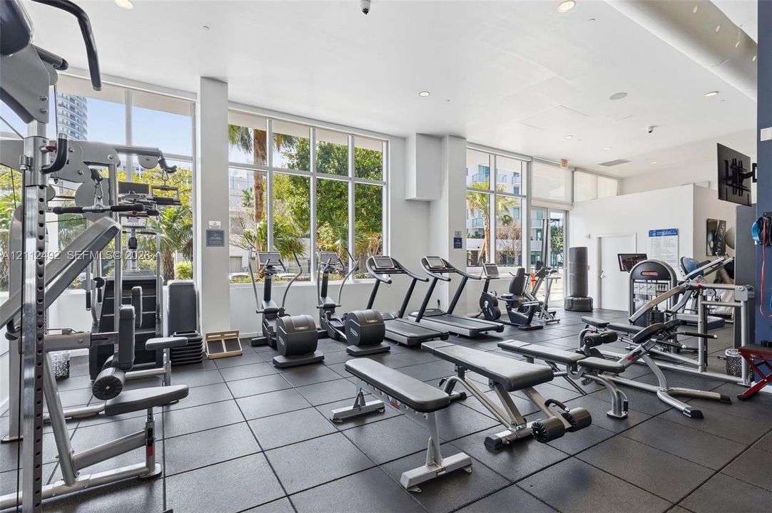 Fitness center featuring floor-to-ceiling windows, rubberized flooring, and recessed lighting