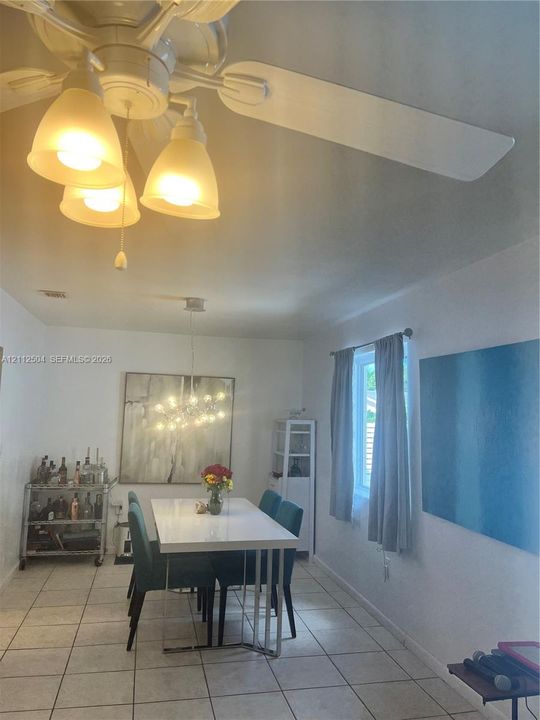 Ceramic tile flooring, white-finished ceiling, multi-light ceiling fan, and multi-light chandelier fixture
