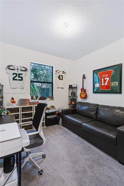 Neutral-toned interior room featuring wall-to-wall carpeting and a single-pane window with dark framing