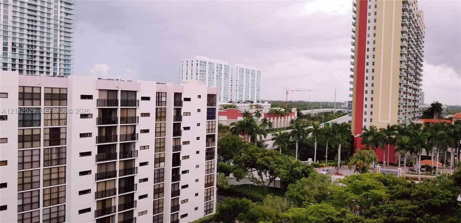 High-rise urban landscape featuring multi-story residential towers, balcony structures, and mature palm trees