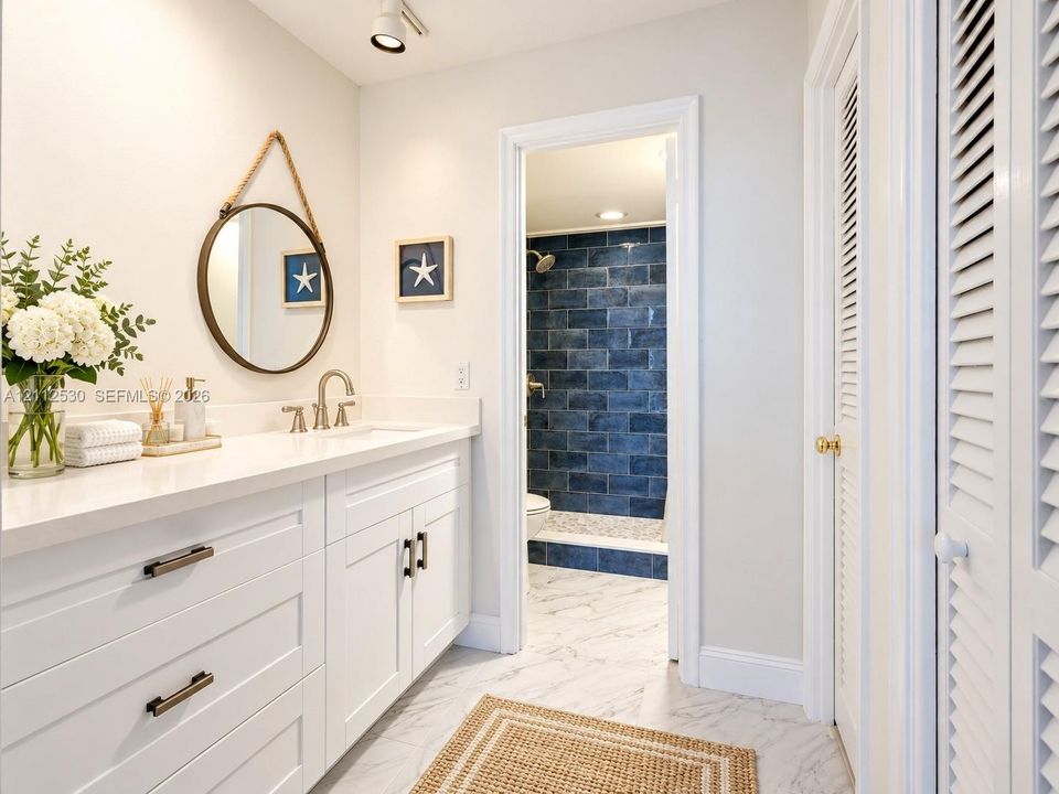 White cabinetry vanity with solid surface countertop, polished metal faucet, recessed ceiling lighting, and stone-finish flooring with a separate tiled shower enclosure