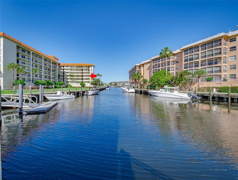 Waterfront condominium complex featuring concrete boat slips, direct canal access, and landscaped grounds
