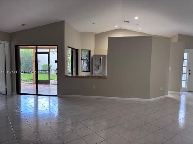 Vaulted ceilings, ceramic tile flooring, sliding glass doors to a screened lanai, and recessed lighting