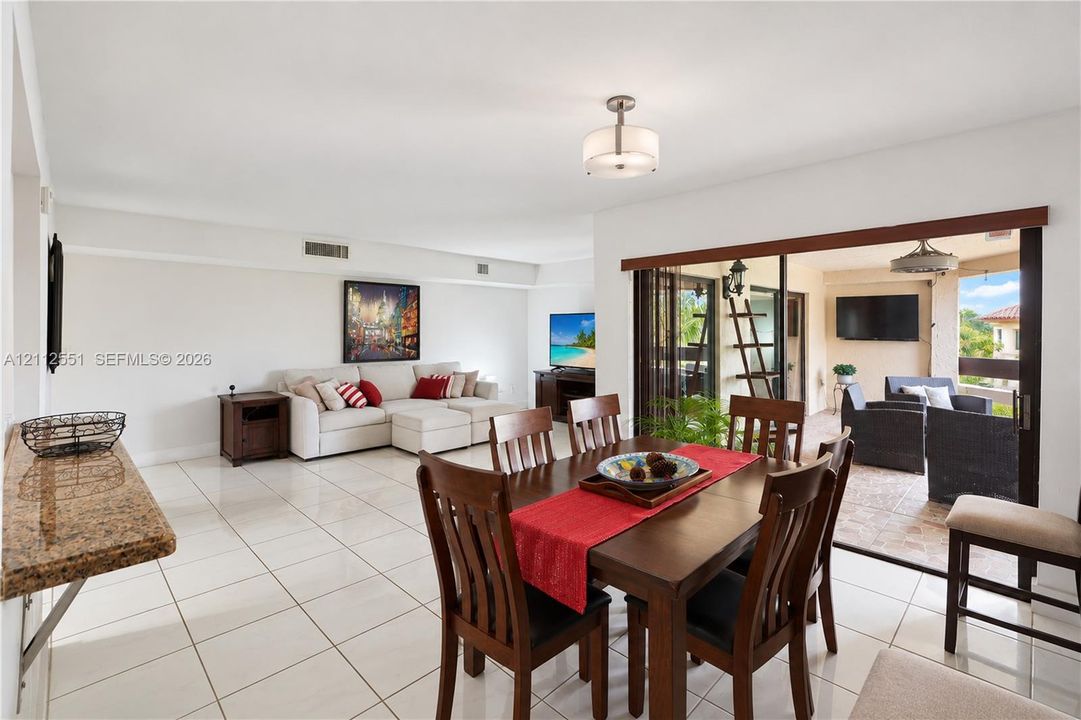 Open-concept interior featuring oversized tile flooring, a stone-surfaced built-in counter, drum-style ceiling lighting, and expansive glass sliding doors