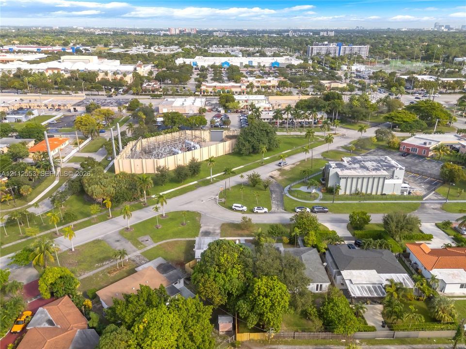 Aerial perspective featuring mature trees, landscaped lawns, and diverse residential housing stock within a suburban setting