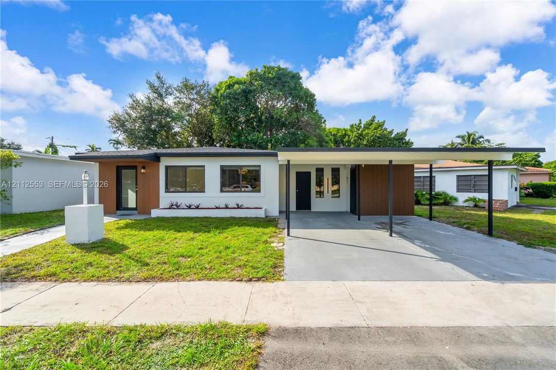 Mid-century modern exterior featuring wood-tone paneling, white stucco facade, flat roofline, and attached carport with metal support columns