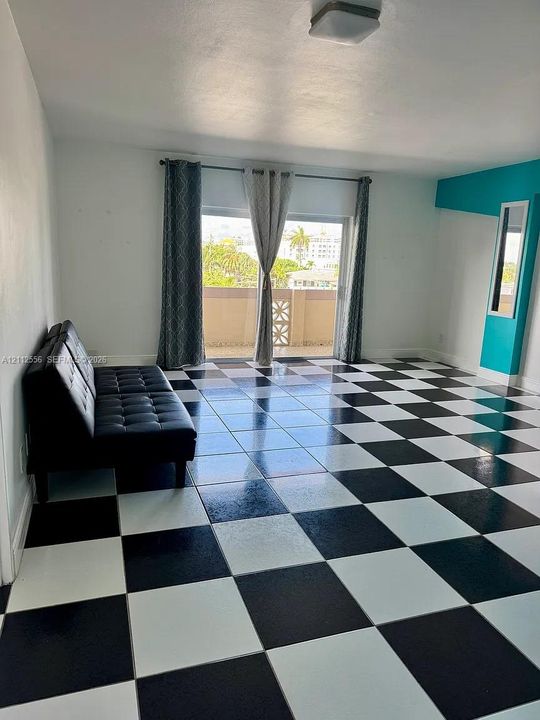 Black and white checkerboard tile flooring, sliding glass door, and a built-in vertical accent wall with a recessed mirror