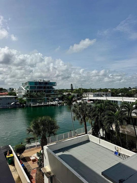 Waterfront property featuring a canal, palm trees, and structural hardscaping