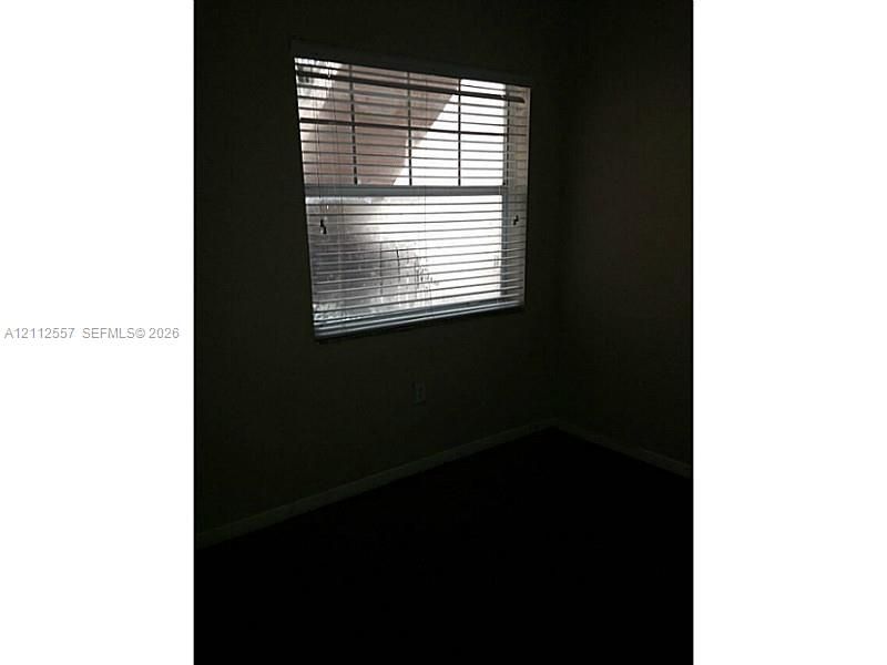 Single-hung window featuring horizontal blinds and neutral-toned wall paint