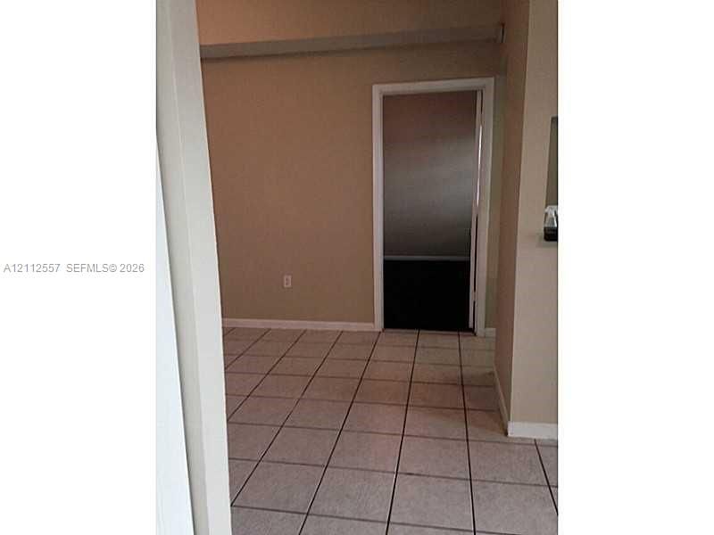 Interior space featuring neutral-toned walls and light-colored square tile flooring