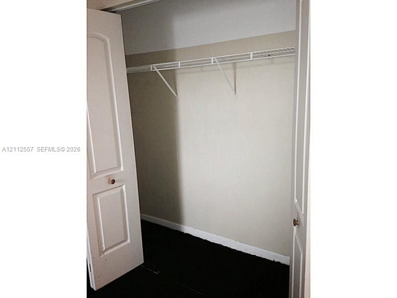 Storage closet featuring white paneled bifold doors and a built-in wire shelving unit
