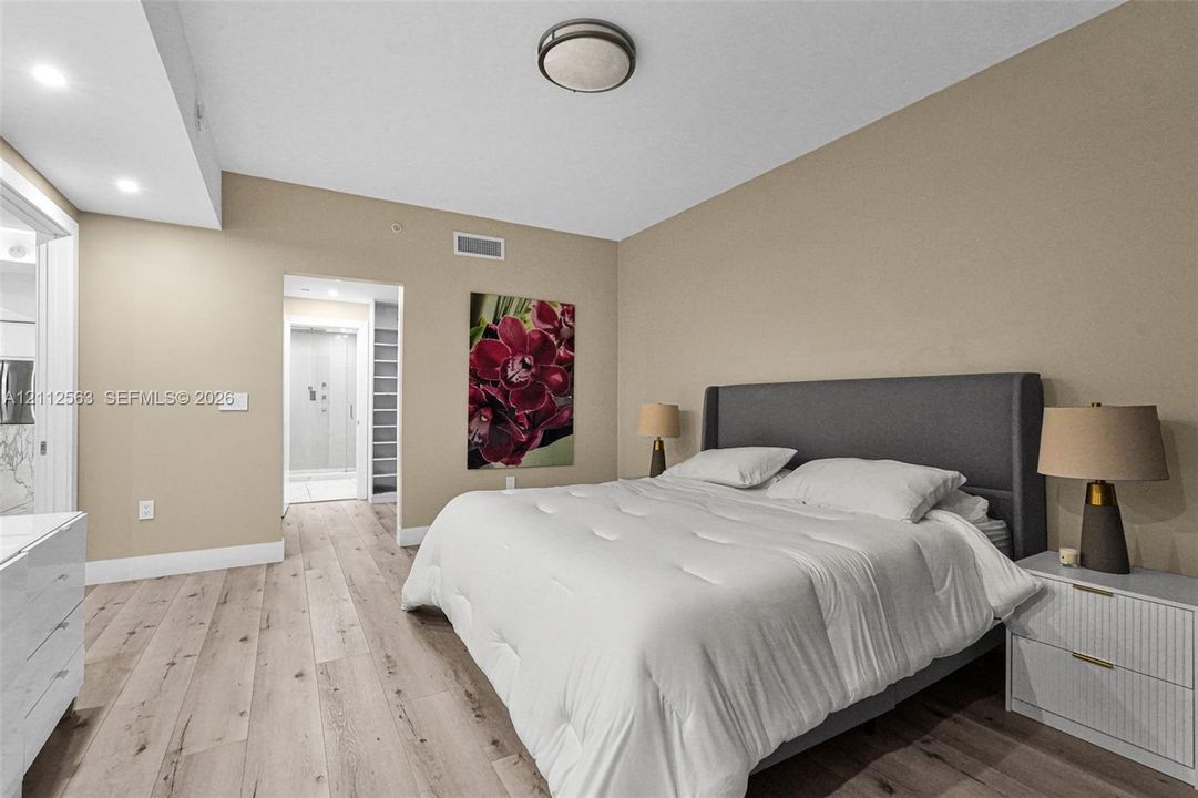 Wood-finish flooring, neutral wall tones, and integrated overhead lighting