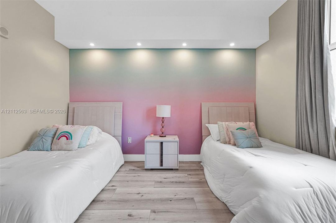 Wood-finish flooring, recessed ceiling lighting, and a focal wall with a gradient finish
