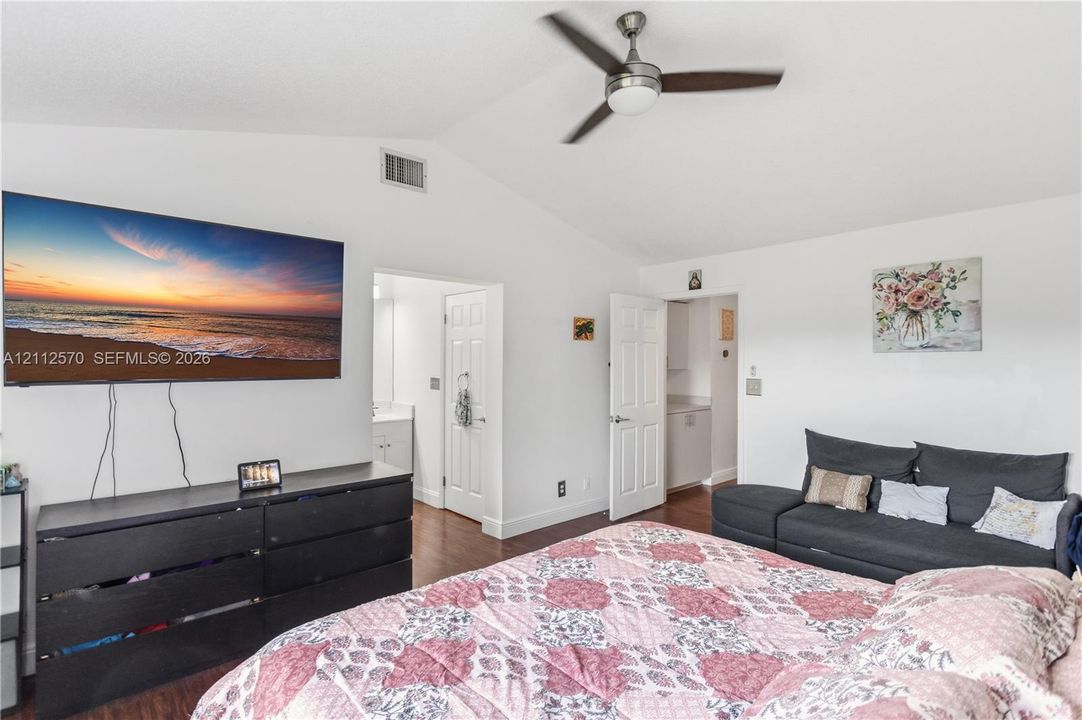 Vaulted ceilings, wood-finish flooring, and a ceiling fan with integrated lighting