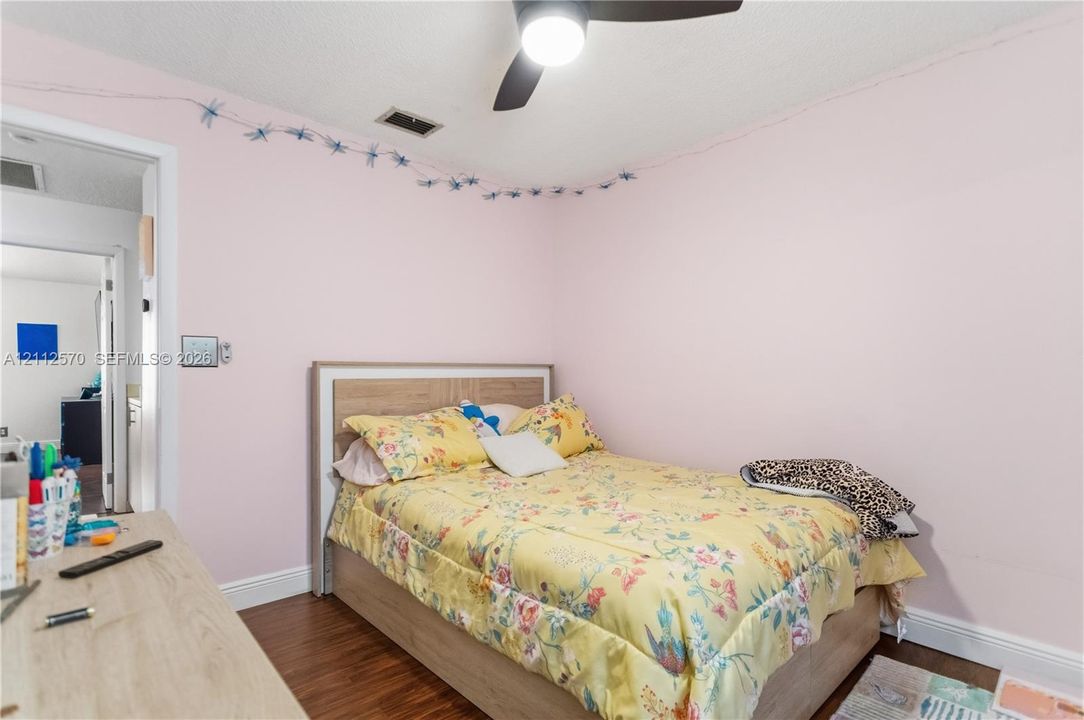 Wood-finish flooring and a central ceiling fan with an integrated light fixture