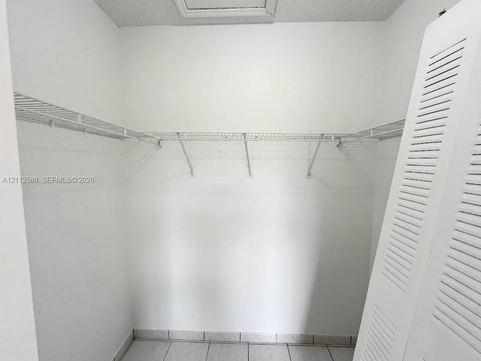Storage area featuring wire shelving and white louvered doors