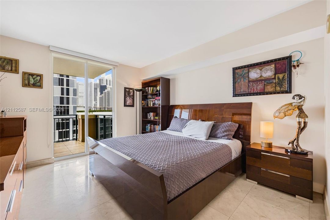 Interior space featuring light-toned tile flooring, built-in shelving, and a glass sliding door providing access to a private balcony