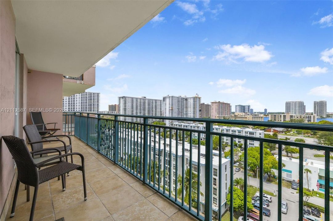 Covered balcony featuring tile flooring and a metal railing