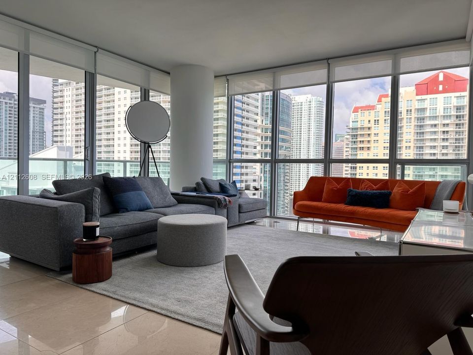 Floor-to-ceiling windows, ceramic tile flooring, and a structural column