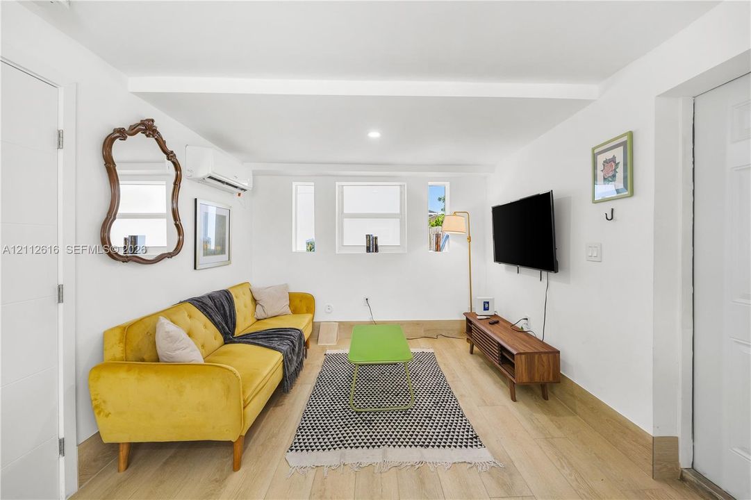 Neutral interior space featuring wood-finish flooring, recessed lighting, and a wall-mounted ductless heating and cooling unit