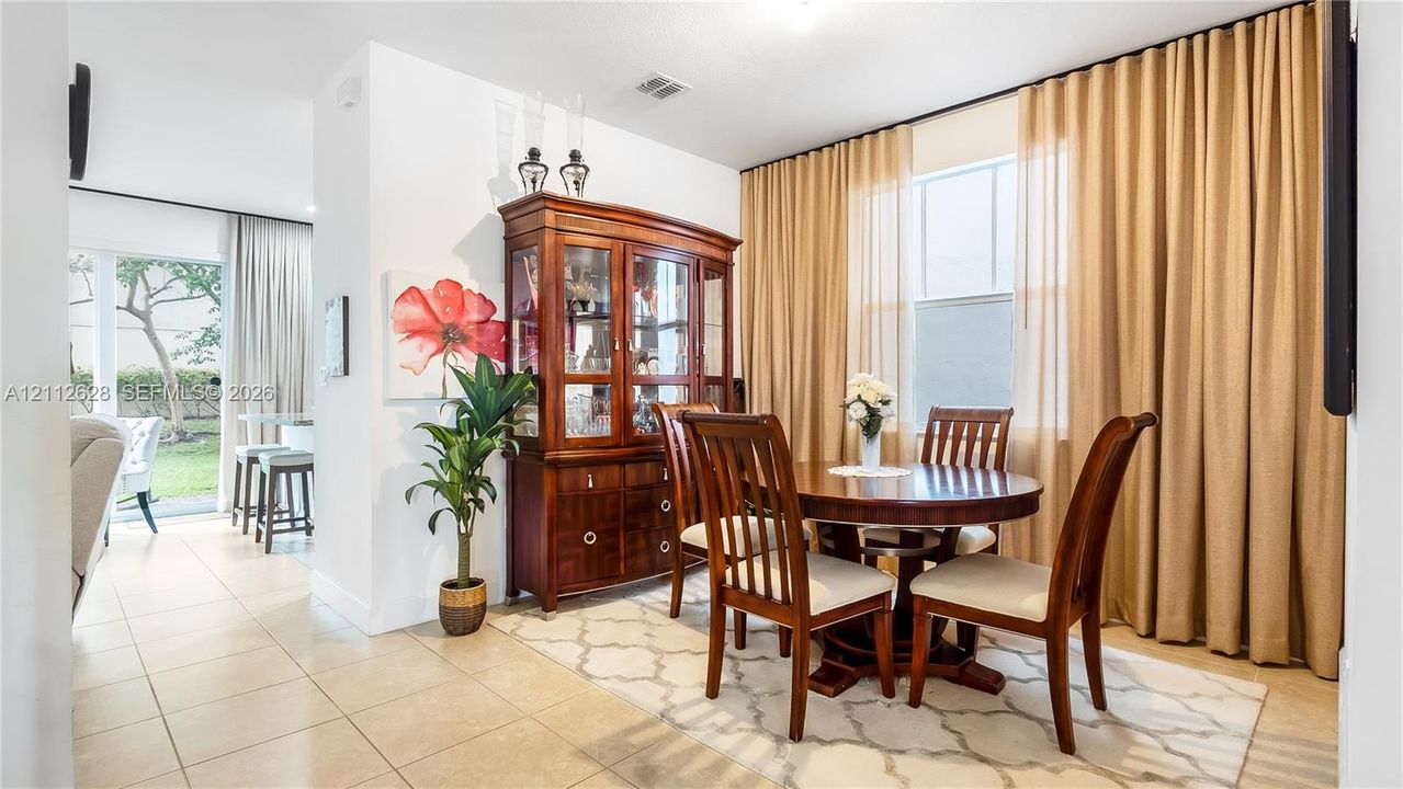 Framed by beautiful drapery and soft natural light, this dining area elevates every meal into an experience—perfect for both relaxed evenings and special occasions.