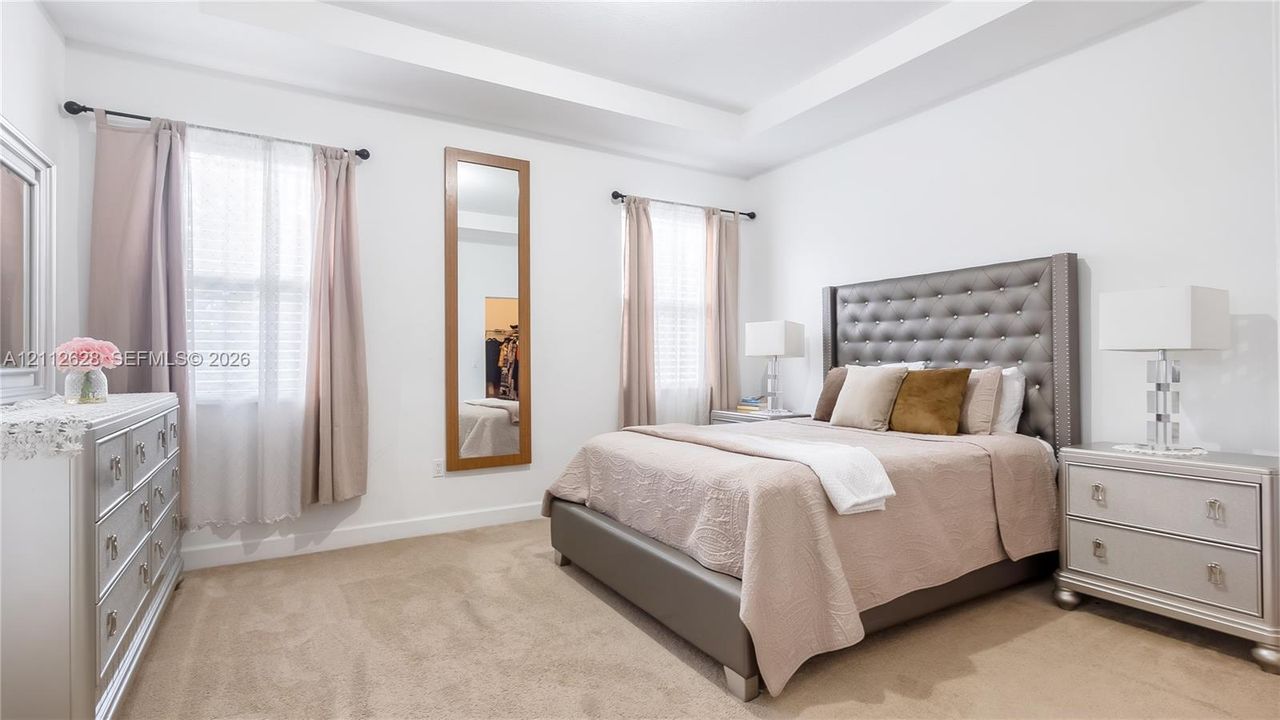 Retreat to a bright and spacious primary suite featuring elegant tray ceilings, abundant natural light, and a serene ambiance—complete with a generous walk-in closet and an oversized ensuite bathroom for the ultimate everyday luxury