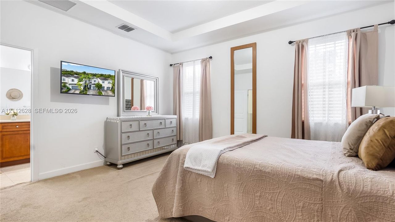 This refined primary bedroom blends comfort and sophistication, offering ample space to unwind along with a spacious walk-in closet and a beautifully appointed oversized ensuite bathroom designed for resort-style living.