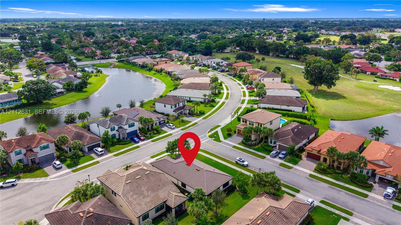 Aerial perspective featuring a tile roof, concrete driveway, and established landscaping within a suburban community