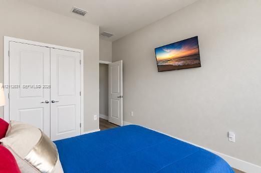 Neutral interior featuring light-toned walls, double-panel closet doors, and wood-finish flooring