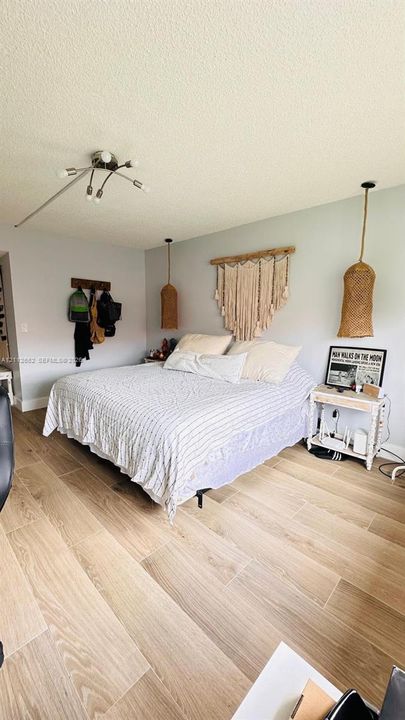 Wood-finish flooring, multi-arm ceiling light fixture, and woven pendant lighting