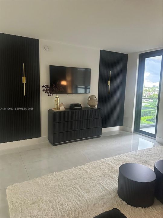 Large-format floor tile, black vertical slat feature wall accents, and slim metallic wall-mounted lighting fixtures