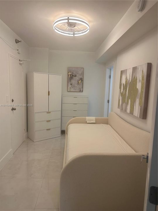 Room featuring large-format tile flooring and a circular flush-mount LED ceiling light fixture
