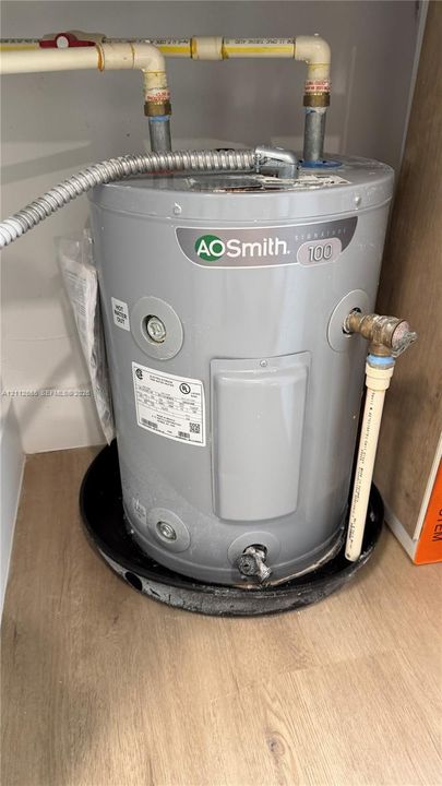 AO Smith Signature 100 water heater with a drain pan, installed with flexible conduit and CPVC piping