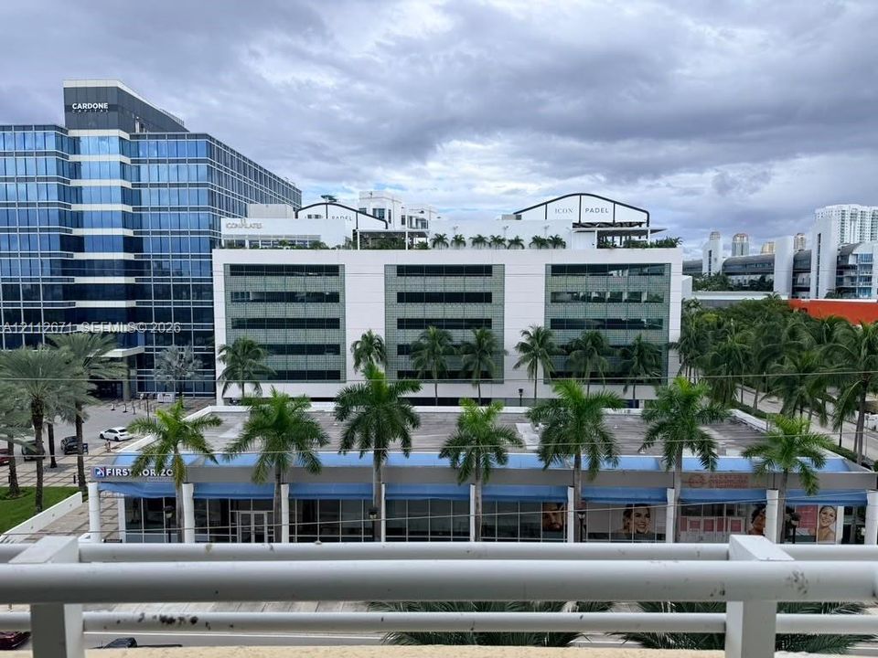 Elevated balcony featuring a white metal railing and a direct perspective of the surrounding urban landscape