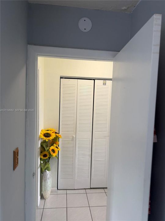 White louvered bifold closet doors and tiled flooring