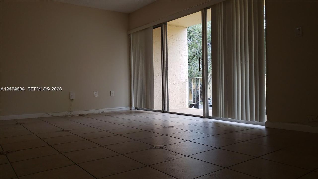 Neutral tile flooring, sliding glass door, and exterior balcony