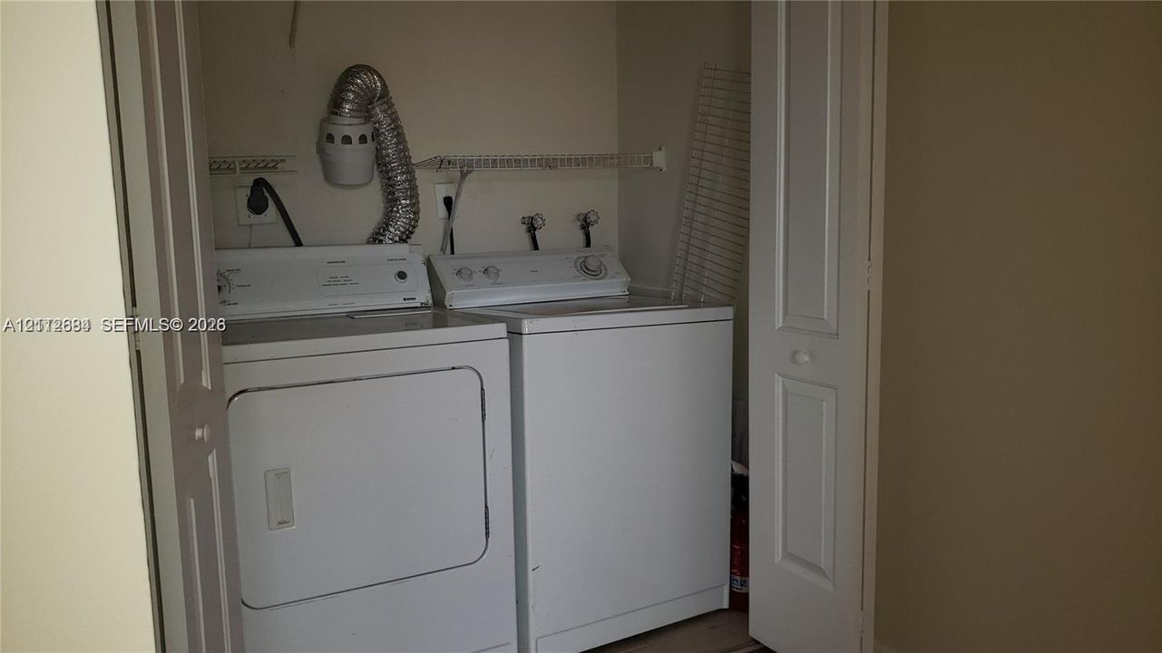 Laundry closet featuring built-in shelving and side-by-side laundry hookups