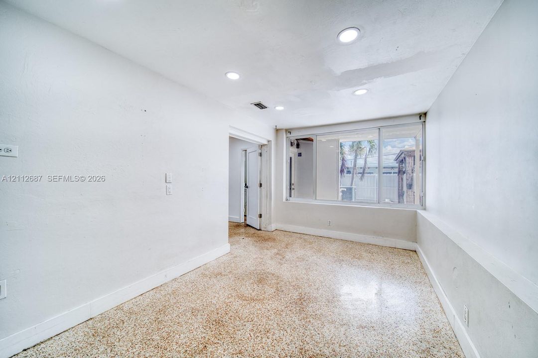 Interior space featuring terrazzo flooring, recessed ceiling lighting, and a multi-panel sliding window