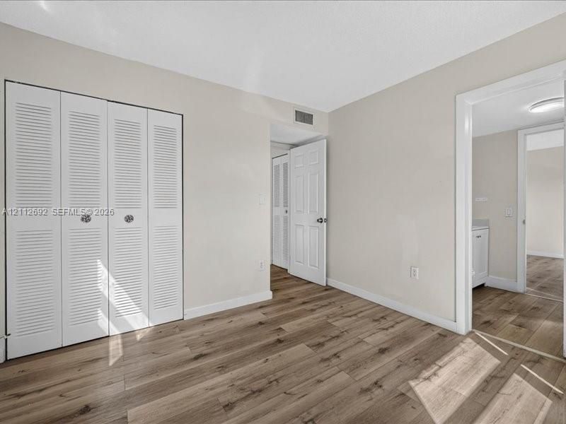 Wood-finish flooring, multi-panel interior doors, and a four-panel louvered closet door