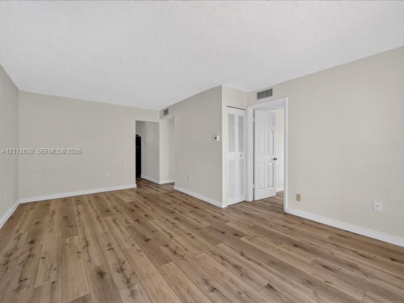 Interior space featuring wood-finish flooring, neutral wall tones, and a six-panel interior door