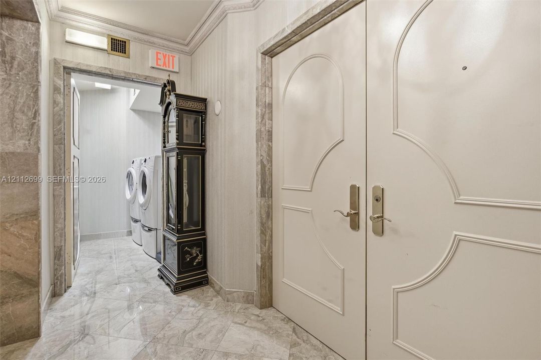 Double entry doors featuring arched molding, stone flooring, and stone wall trim