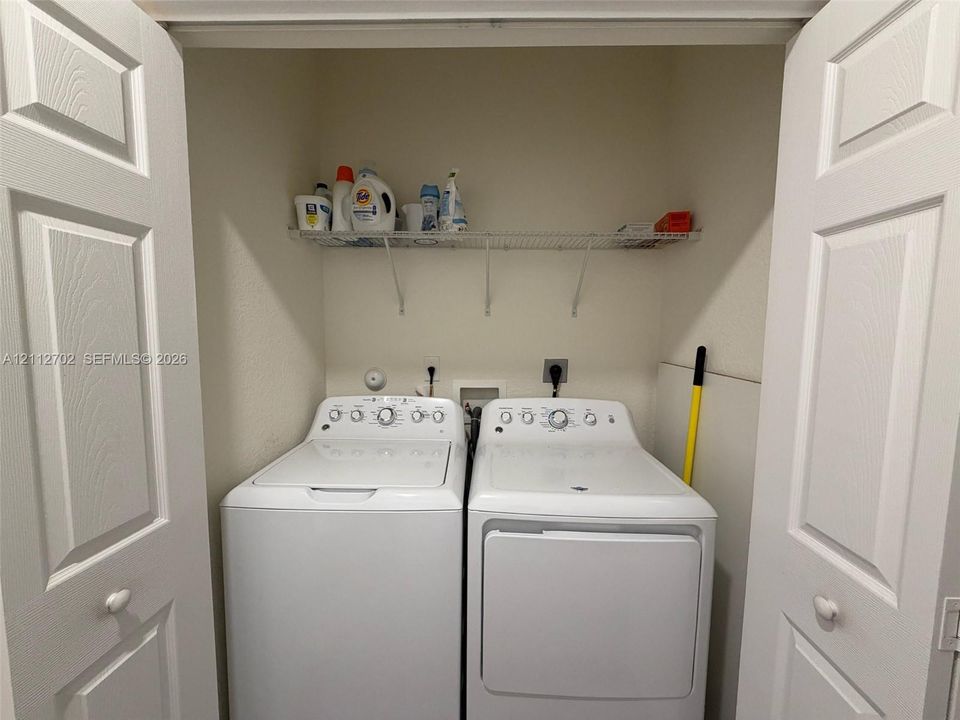 Laundry alcove featuring double-panel interior doors and an integrated wire shelving unit