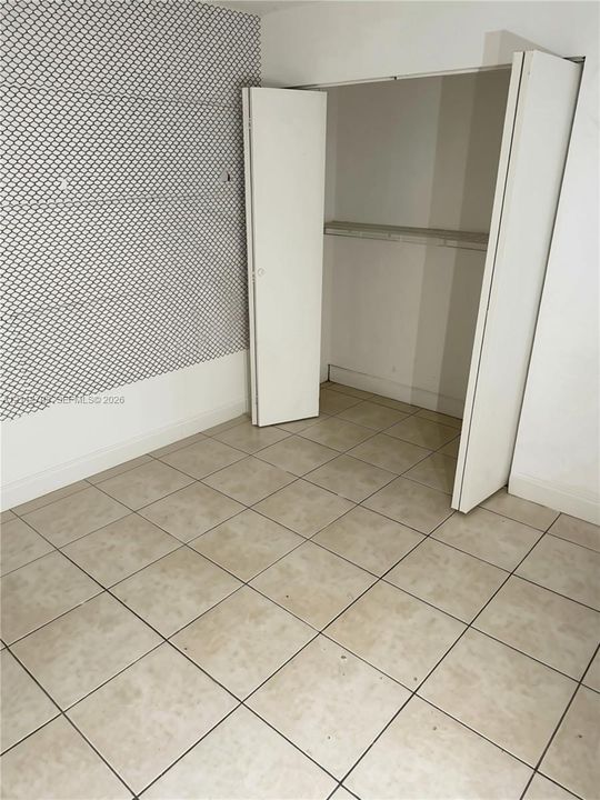 Ceramic tile flooring, bi-fold closet doors, and built-in closet shelving