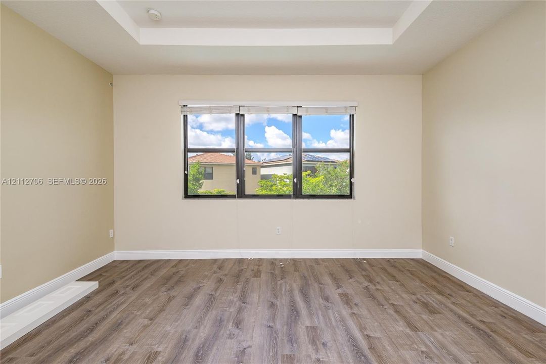 Trey ceiling, wood-finish flooring, and multi-pane window with dark frames