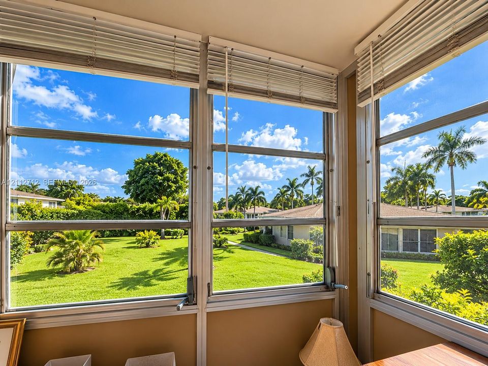 Enclosed porch featuring expansive multi-pane windows and horizontal slat blinds