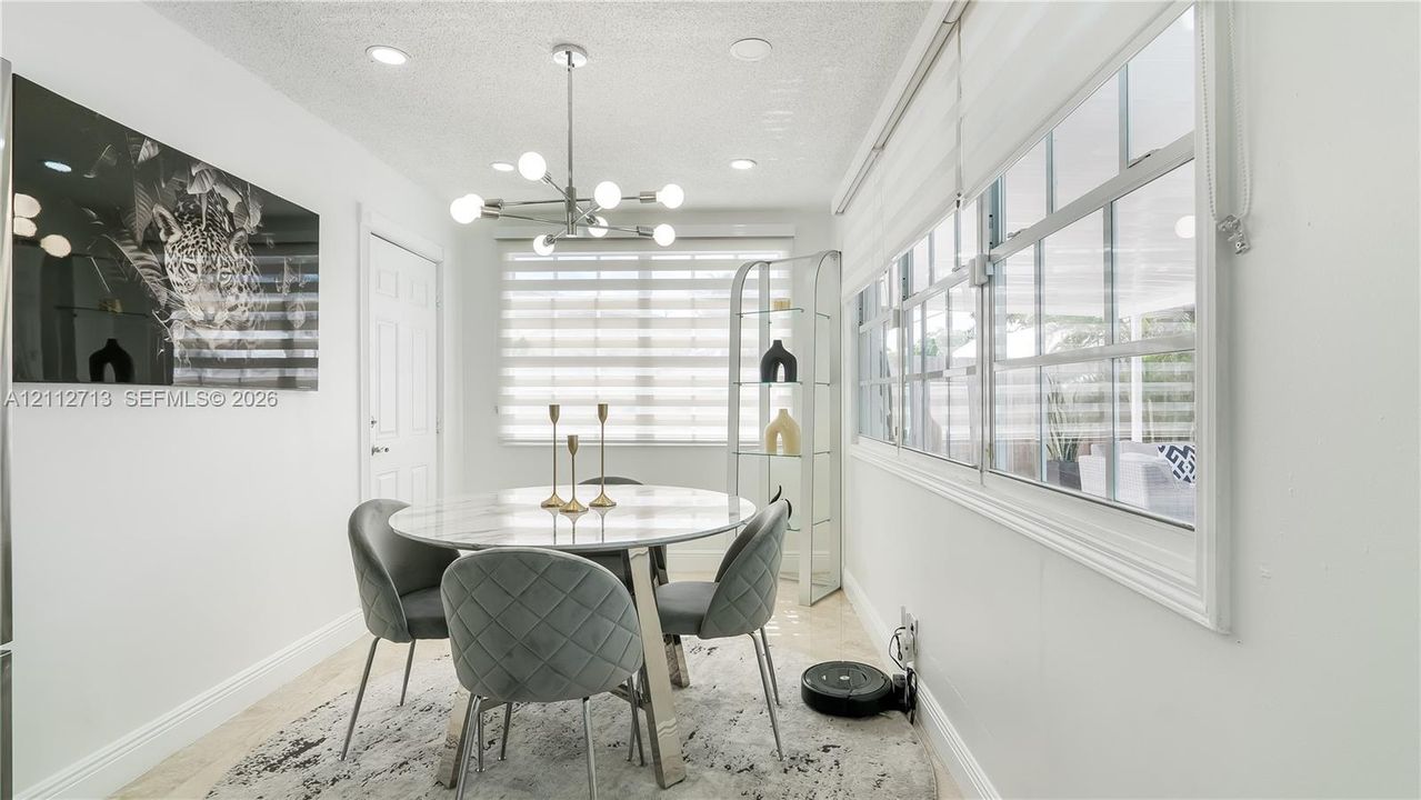 Dining area featuring recessed lighting, a modern multi-bulb chandelier, large windows with horizontal blinds, and tile flooring