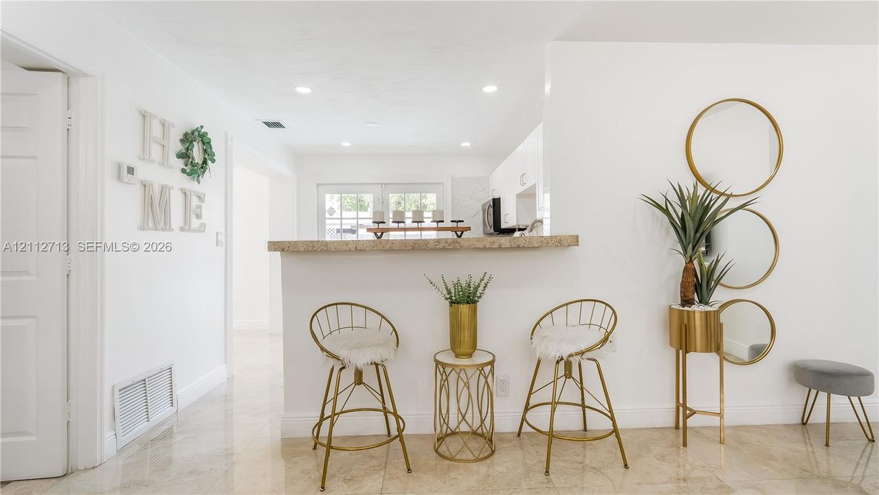 Pass-through service bar with a stone-finish countertop and recessed ceiling lighting throughout the interior