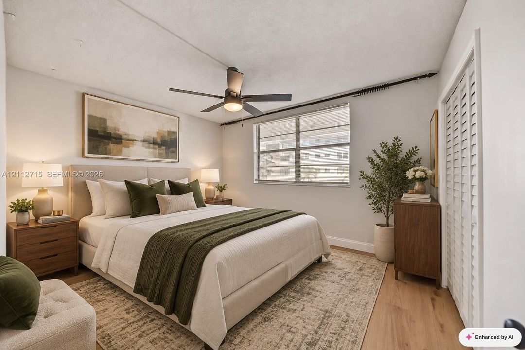 Bedroom featuring wood-finish flooring, a multi-blade ceiling fan with integrated lighting, and louvered closet doors